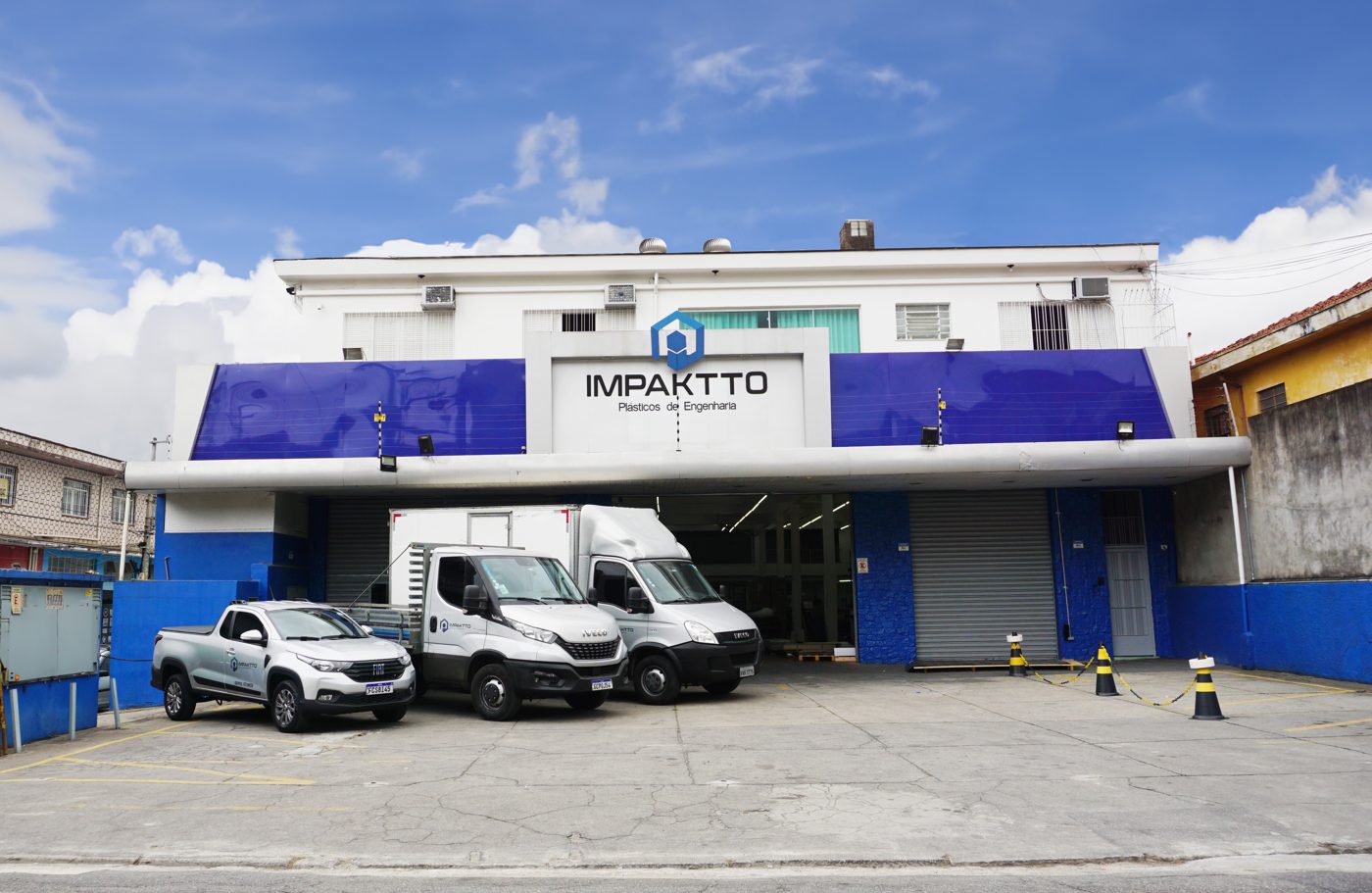 Fachada da fábrica da Impaktto, com veículos de entrega estacionados